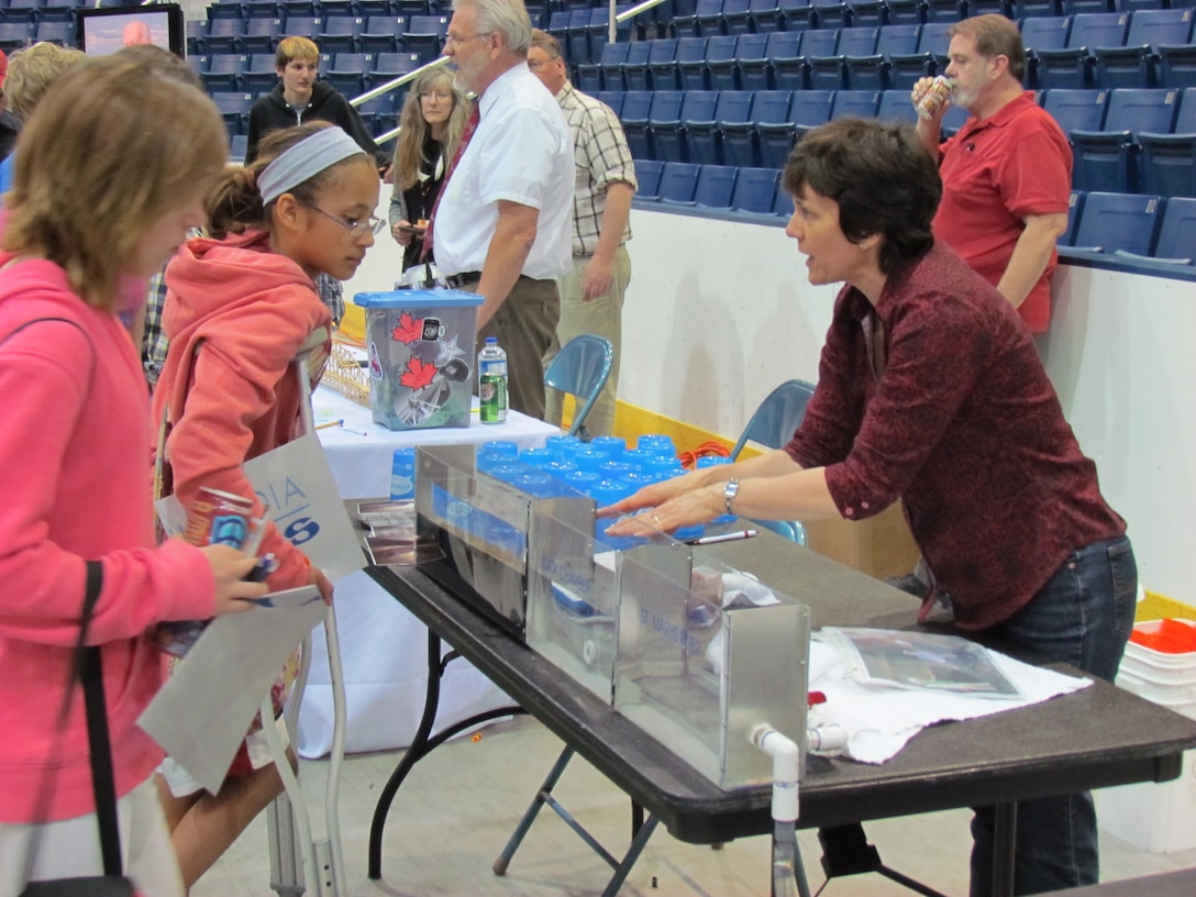 Civil engineer Joanne Gray from the Soo Area offices uses a lock model to demonstrate how valves and gravity are used at the Soo Locks to move water in and out of the lock chamber.  Gray and several other engineers spoke with students during a science exploration day at Lake Superior State University.