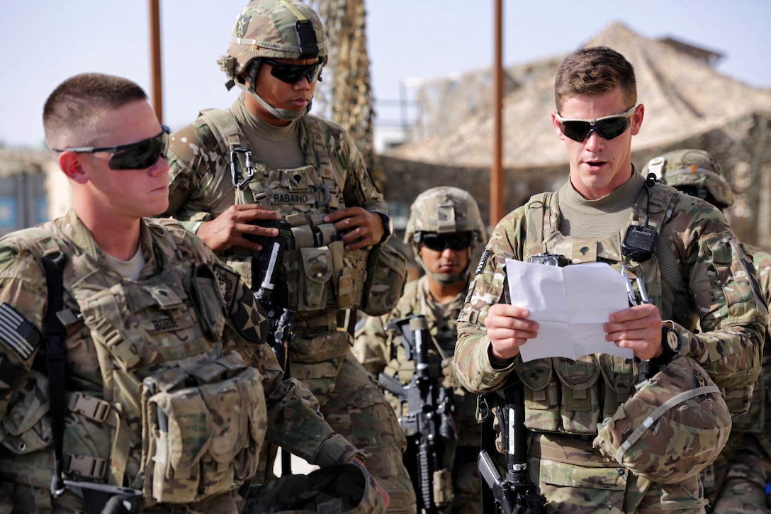 U.S. Army Spc. Matt Cullen, right, conducts a mission brief before ...