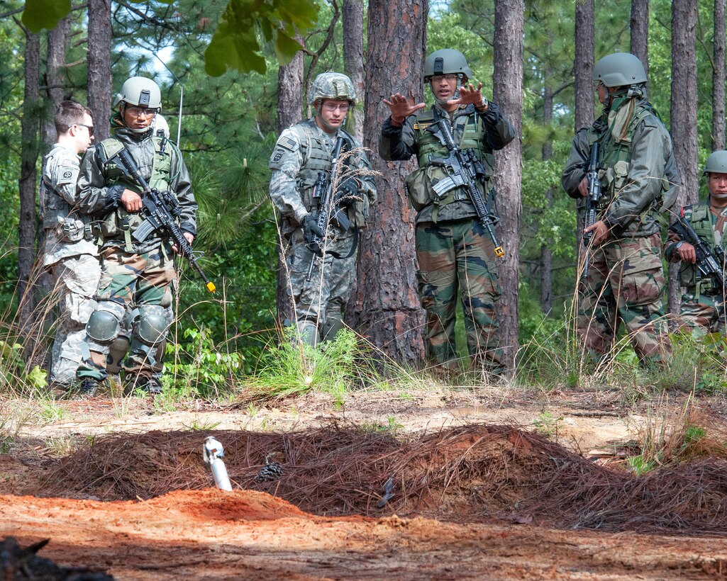 Indian army Maj. Prashant Mishra, center right, explains how his soldiers deal with unexploded munitions to U.S. Army Sgt. Micheal Mark, center left, during Yudh Abhyas 2013 on Fort Bragg, N.C., May 8, 2013. Mishra, a company commander, is assigned to the 99th Mountain Brigade, and Mark, a combat engineer, is assigned to the 82nd Airborne Division’s 1st Brigade Combat Team.