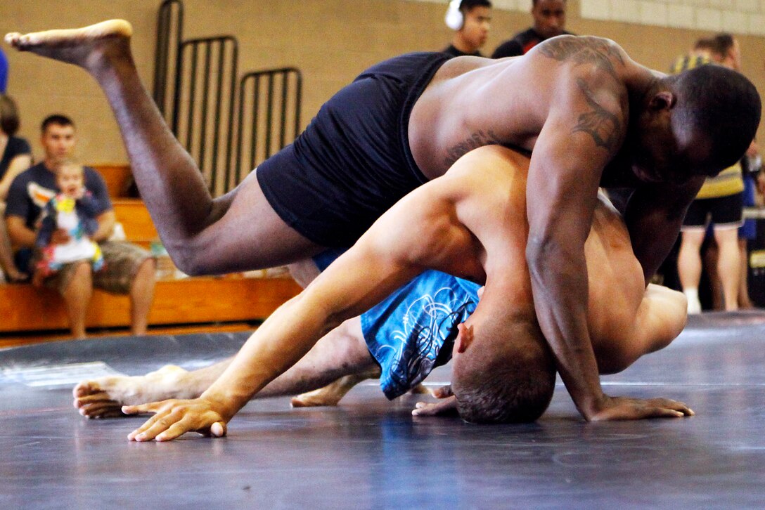 Lance Cpl. Jacob Stremkowski and Cpl. Austin Ragland grapple during the U.S. Military Pankration Championships held at the 52-area fitness center here May 18.  The U.S. Military Pankration Championships are held annually by U.S. Fight League and Semper Fit, open to all service members. Ragland is an avionics technician with Marine Light Attack Helicopter Squadron 465 at the air station here and Stremkowski is a combat engineer with the 1st Combat Engineers Battalion here. 