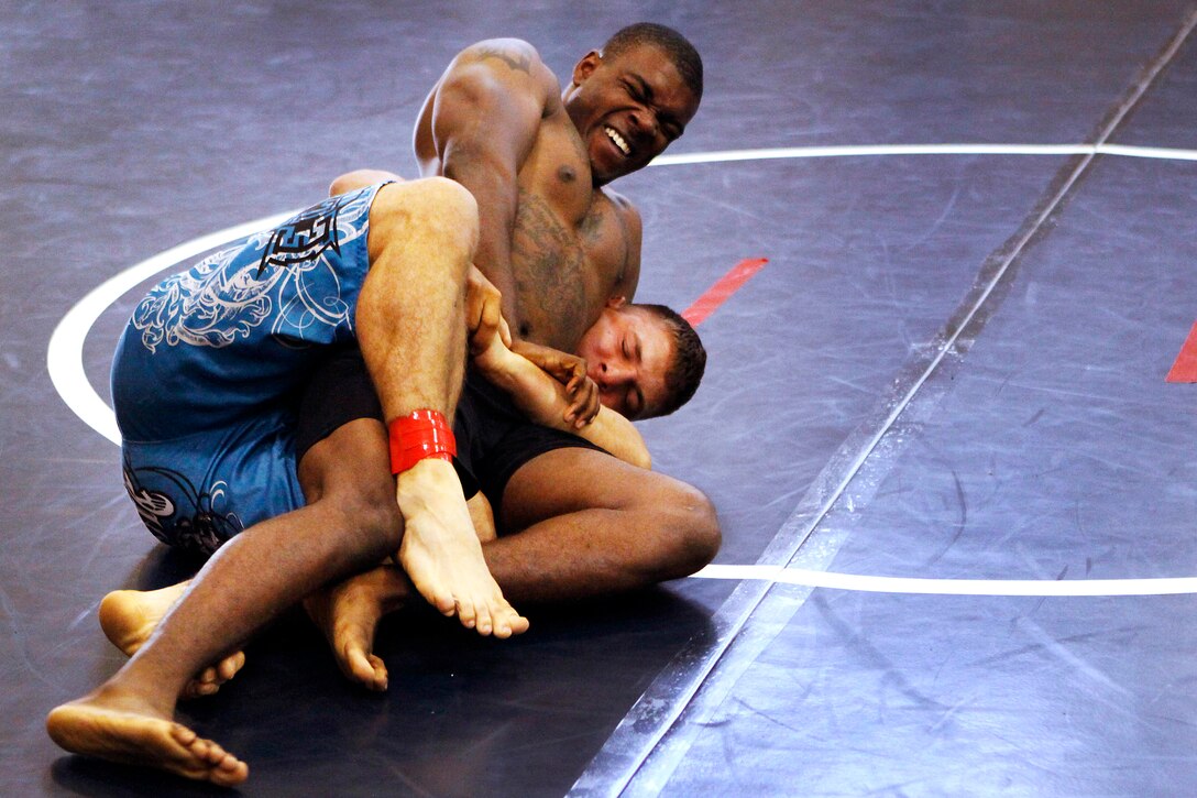 Cpl. Austin Ragland is struggling to get out of a lock that Lance Cpl. Jacob Stremkowski has caught him in during a grappling match in the first half of the U.S. Military Pankration Championships held at the 52-area fitness center here May 18. The U.S. Military Pankration Championships are held annually by U.S. Fight League and Semper Fit on Camp Pendleton for all service members. Ragland is an avionics technician with Marine Light Attack Helicopter Squadron 465 at the air station here and Stremkowski is a combat engineer with the 1st Combat Engineers Battalion here. 