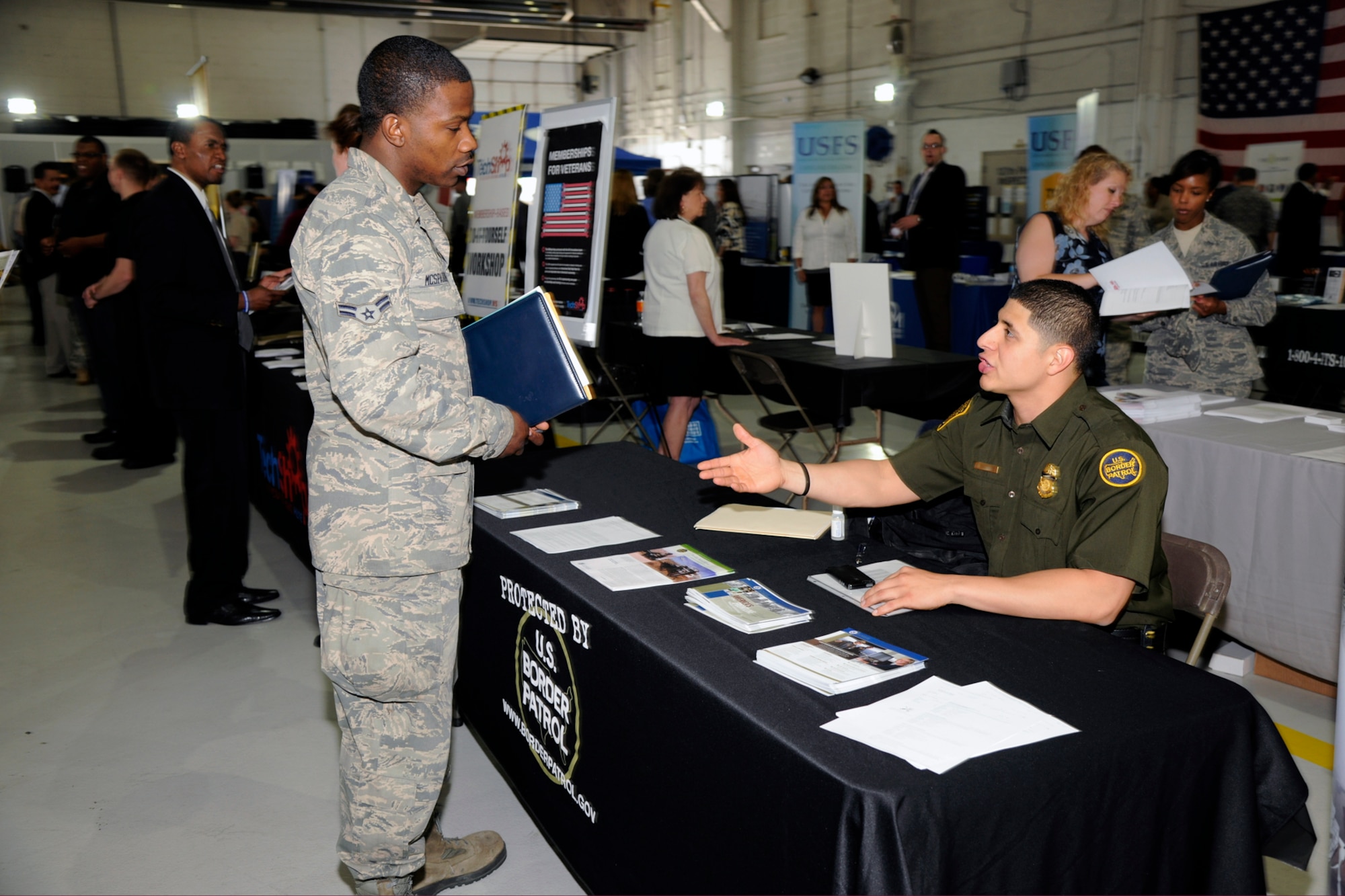 Airman 1st Class Onnie Mcspadden of the 127th Aircraft Metals Tech speaks with a representative of the U.S. Border Patrol during the Hiring Our Heroes job fair at Selfridge Air National Guard Base, Mich., May 18, 2013. Mcspadden, recently returned from his technical school, attended the job fair to explore possible career opportunities in law enforcement. More than 300 job seekers attended the fair at Selfridge, visiting with representatives from more than 53 employers. (U.S. Air National Guard photo by TSgt. David Kujawa