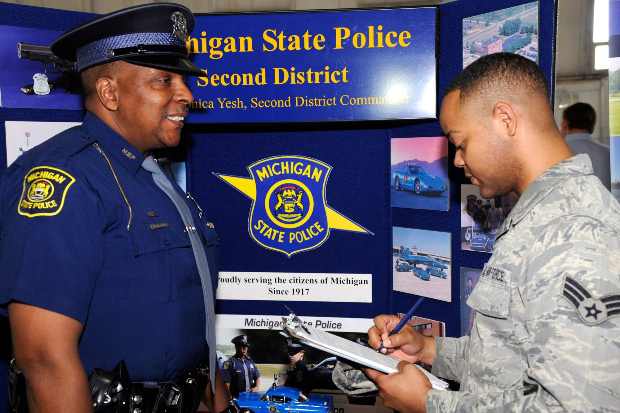 Senior Airman Alfonzsa Jackson of the 127th Maintenance Squadron speaks with Trooper Walter Crider of the Michigan State Police during the Hiring Our Heroes job fair at Selfridge Air National Guard Base, Mich., May. 18, 2013. Jackson, a six year member of the Air National Guard and recently a member of the 127th MXS Aerospace Ground Equipment crew, attended the job fair to explore possible career opportunities in law enforcement. More than 300 were in attendance visiting with representatives of more than 50 employers. (U.S. Air National Guard photo by TSgt. David Kujawa)
