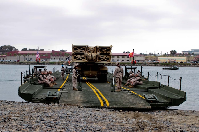Marines serving with 1st Combat Engineer Battalion and 7th Engineer Support Battalion demonstrate bridging capabilities at the Camp Del Mar basin here, May 16, 2013. The Improved Ribbon Bridge is designed to carry heavy vehicles including the M1A1 Abrams Tank. During the demonstration, the bridge supported an Armored Vehicle-Launched Bridge traveling into the basin.