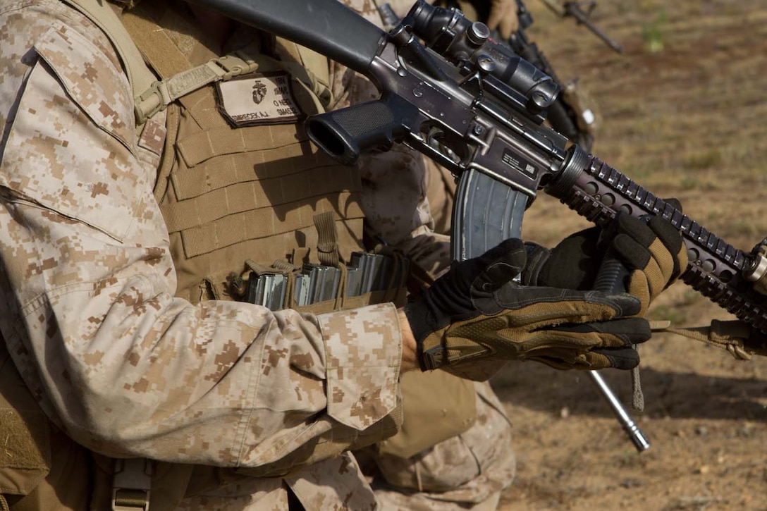 Lance Cpl. Andrew Smrecek, a rifleman serving with Bravo Company, 1st Battalion, 1st Marine Regiment, loads and makes ready, before assault training exercise here, May 15, 2013. The training was designed to give fire team leaders and squad leaders practice leading their Marines in combat. The exercise helped to develop unit cohesion, and communication between members of the squads.