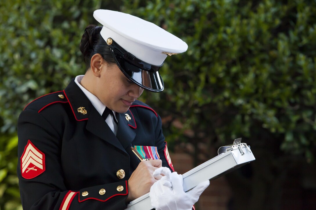 Sgt. Yvonne C. Lelafu, a hoster with Marine Barracks Washington, D.C., checks in guests at the entrance gate prior to a Friday Evening Parade at the Barracks May 17. 