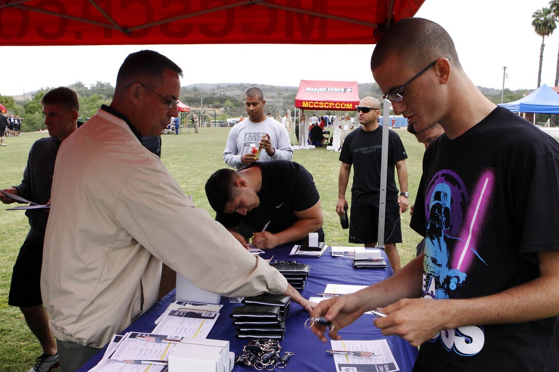 Jim Dickie helps Marines fill out registration forms for a raffle to win a 100-dollar Marine Corps Exchange gift card at the USAA Financial booth during the safety fair held at Lake O’Neill here May 17.  Dickie is a military affairs representative for USAA.  Headquarters and Headquarters Squadron held their annual 101 days of summer safety stand down training in the form of an interactive fair coupled with a squadron sized field meet and competition.