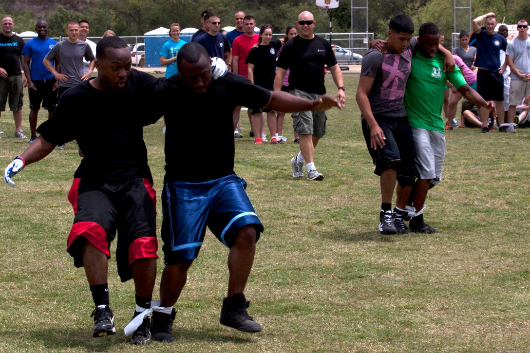 Sgt. Nathan Rembert, left, and Cpl. Larry Haywood compete in the three-legged race portion of a multi-station race during the safety fair and field meet held at Lake O’Neill Recreational Area here May 17. Rembert is a flight clearance chief and Haywood is receiving aviation operations specialist on-the-job training with Headquarters and Headquarters Squadron at the Marine Corps Air Station here.