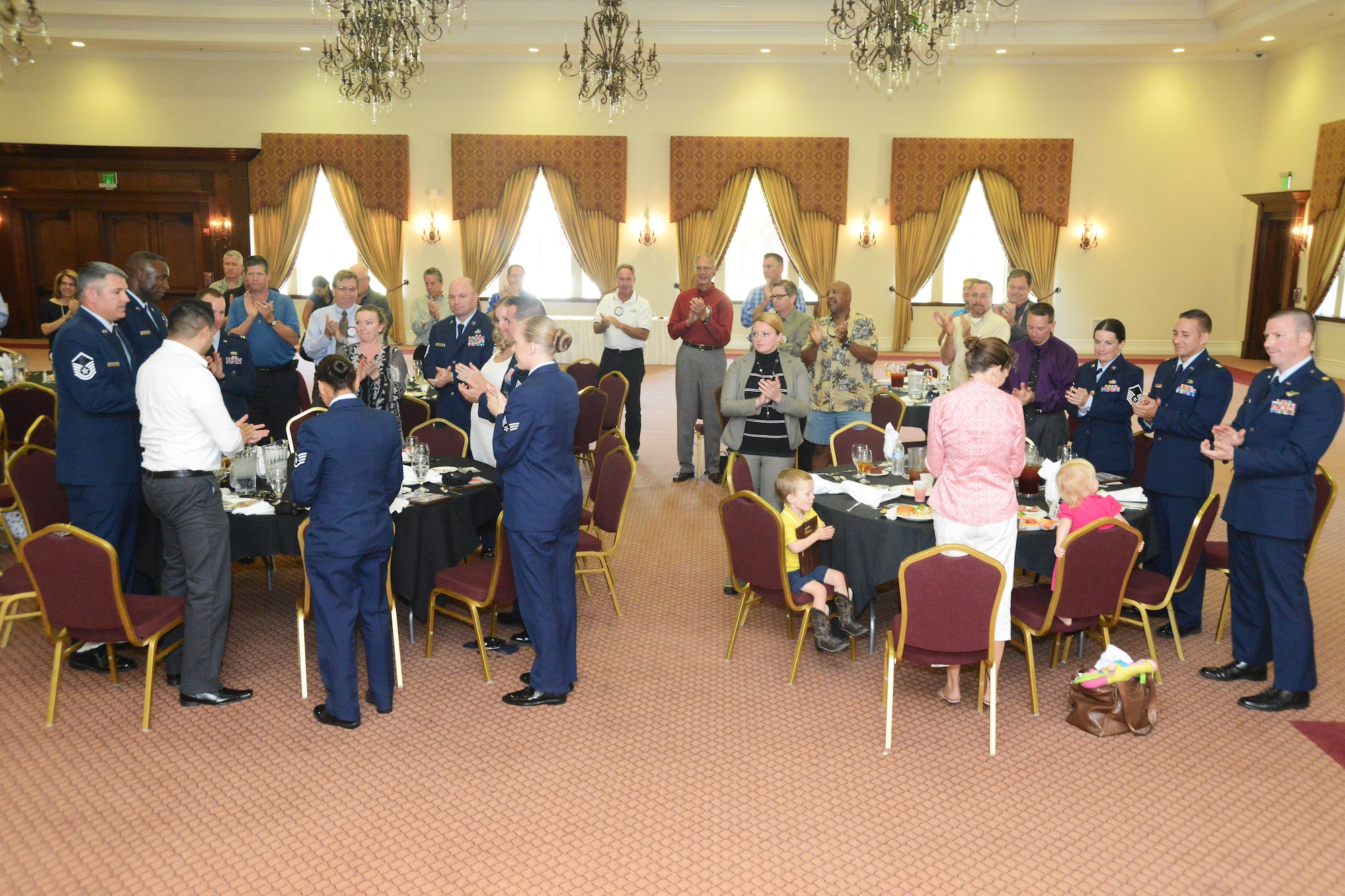 412th Test Wing active duty annual award winners were asked to stand to be applauded by The Rotary Club of Lancaster West May 20, 2013. The awardees and their guests were served lunch at the Hellenic Center in Lancaster, Calif.  The Rotarians wanted to honor local military members and their achievements and invited the five annual award winners, their families and supervisors. (U.S. Air Force photo by Kenji Thuloweit) 
 
 
