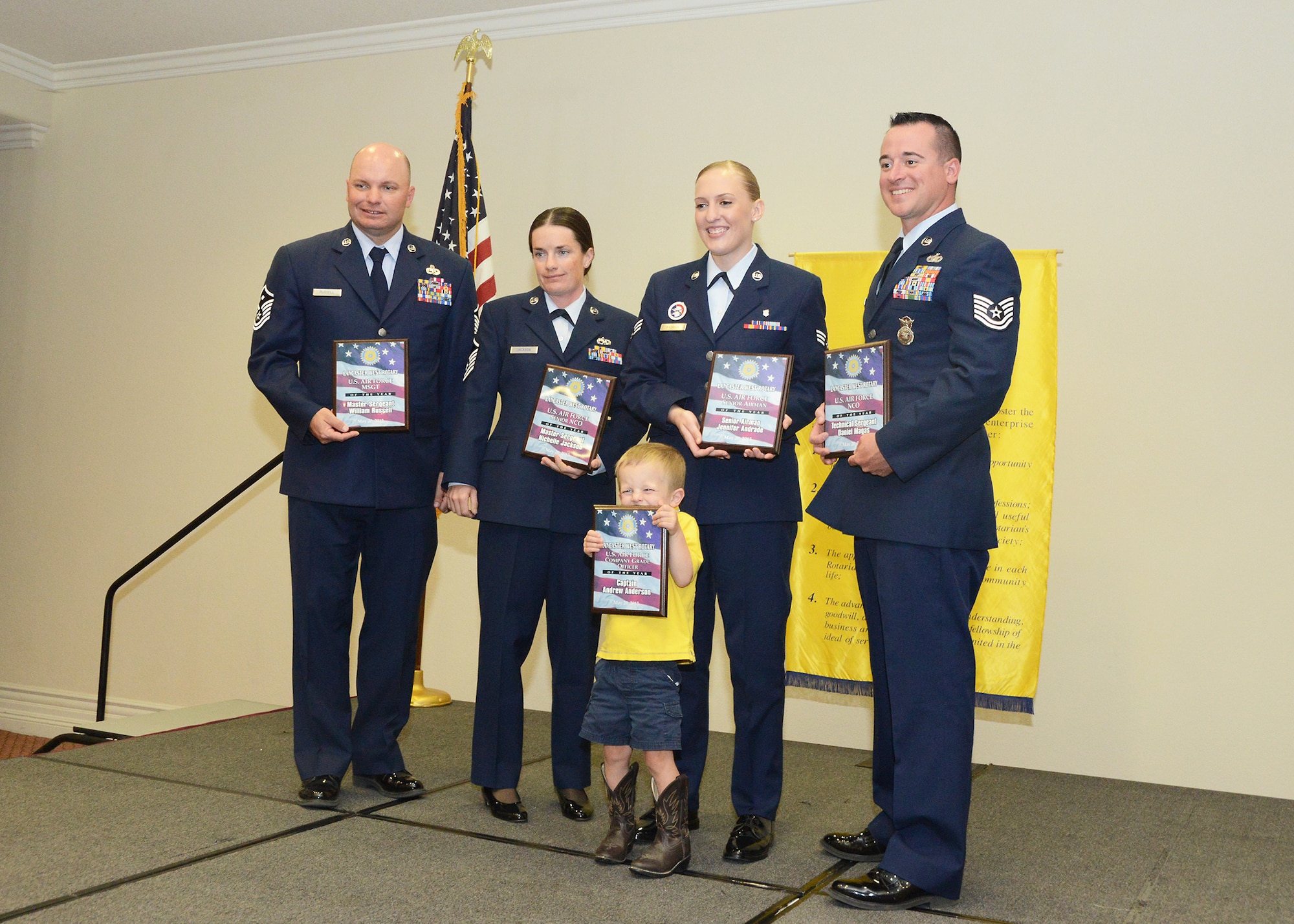 The Rotary Club of Lancaster West wanted to recognize the 412th Test Wing's active duty annual award winners. The awardees along with their supervisors and family were invited to the Hellenic Center in Lancaster, Calif., for a complimentary lunch and award presentation. From left: First Sergeant William Russell, 412th Mission Support Group; Master Sgt. Nichelle Jackson, 412th Aircraft Maintenance Squadron; Senior Airman Jennifer Andrade, 412th Medical Operations Squadron; Tech. Sgt. Daniel Magas, 412th Security Forces Squadron; and (front) Asher Anderson, son of Capt. Andrew Anderson, 419th Flight Test Squadron. (U.S. Air Force photo by Kenji Thuloweit) 
 
 
