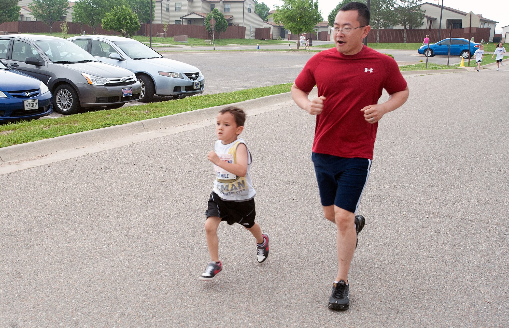 Maj. Robert Liu, 22nd Civil Engineer Squadron operations flight commander, and his son, run side by side May 18, 2013, McConnell Air Force Base, Kan. This was the first year that Liu and his son participated in the Armed Forces Day Kids’ Run. (U.S. Air Force photo/Airman 1st Class Colby L. Hardin)