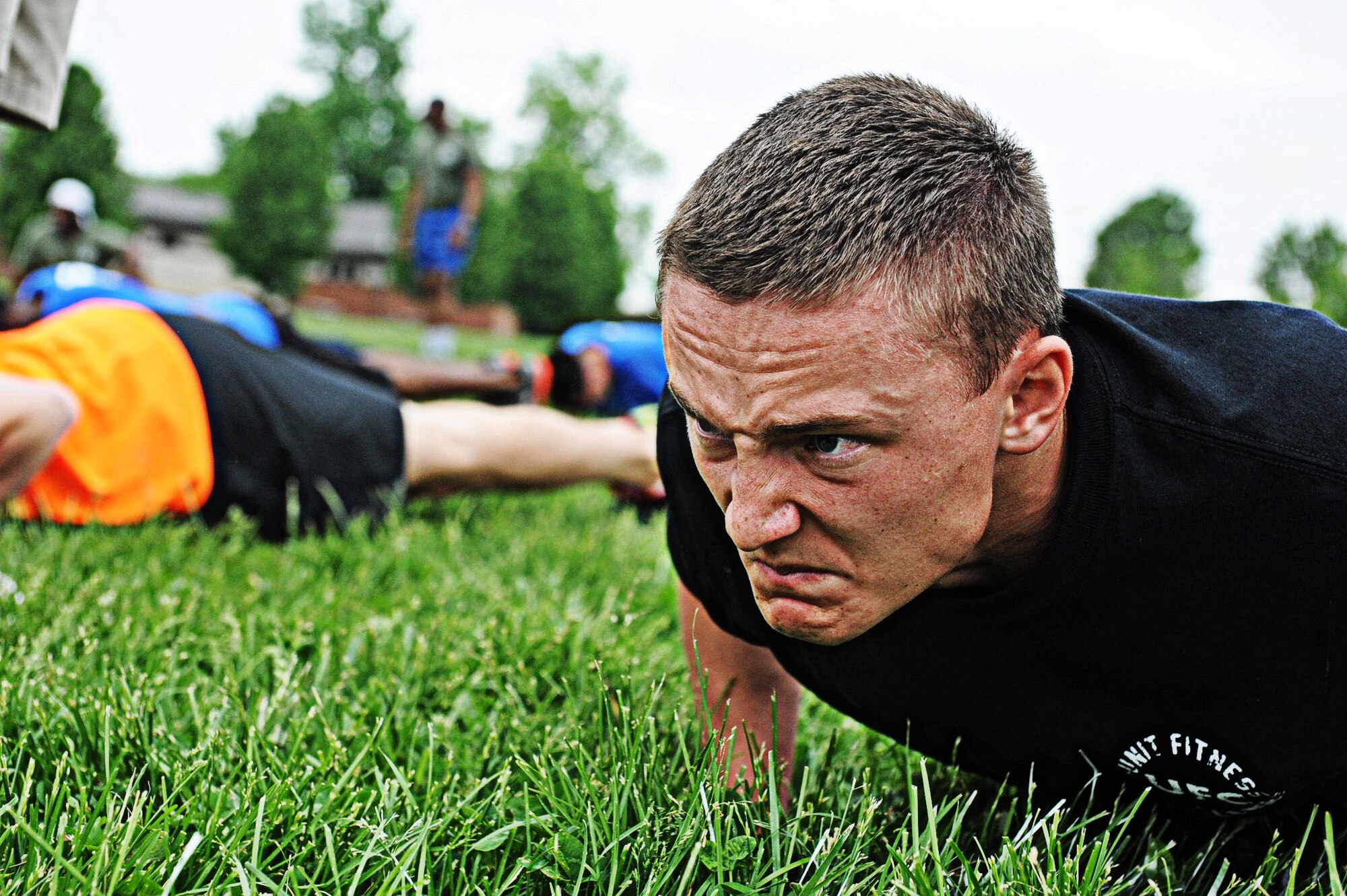 Airman Juneau Shores, 375th Security Forces, tries to keep his body from touching the ground during the frozen push-ups portion of the 2013 Unit Fitness Challenge at the Airman Leadership School May 17. Food was provided after the event was over by the United States Organizations. (U.S Air Force photo/Senior Airman Jake Eckhardt)