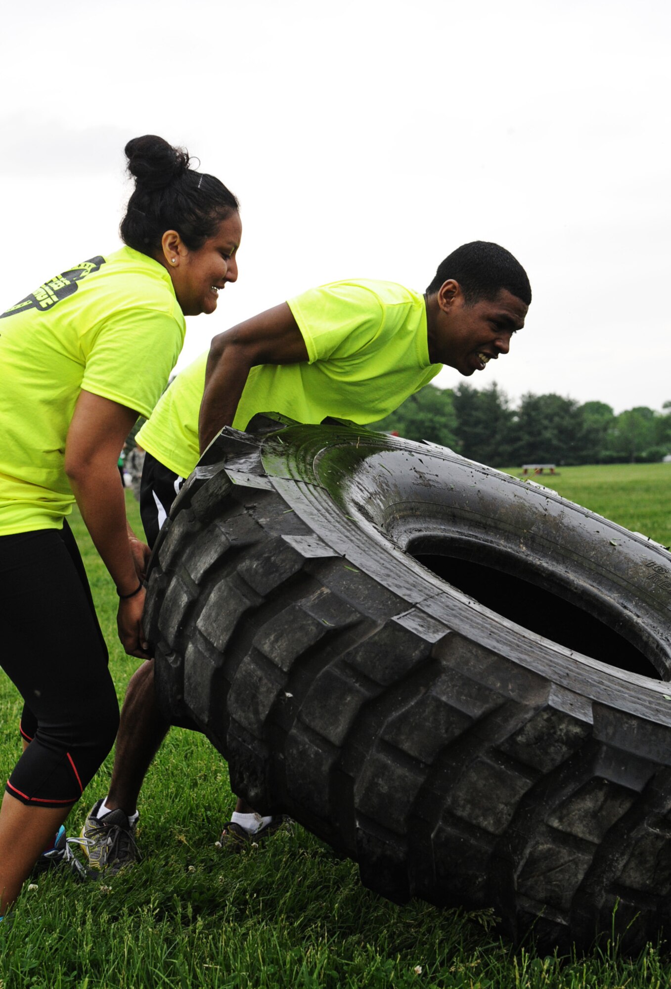 Members of the 375th Force Support Squadron team, First Lt. Claudia Santos and Airman 1st Class Colin Wood, struggle to lift the tire at the Airman Leadership School field May 17. Attendance prizes were drawn in between each exercise. (U.S Air Force photo/Senior Airman Jake Eckhardt)