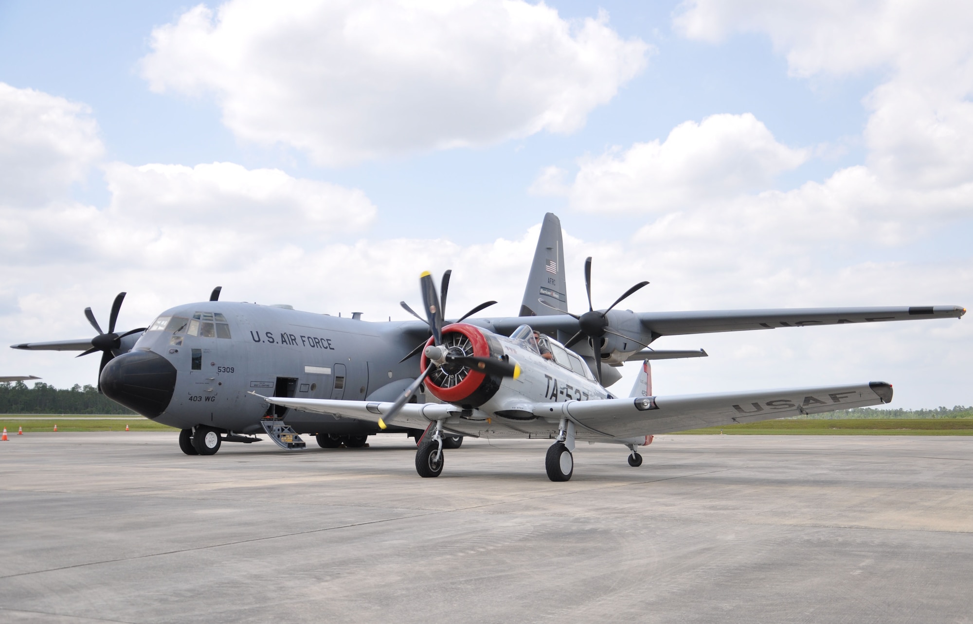 Jay Knowles displays his North American T-6, one of the first aircraft to be flown into a hurricane, next to one of Keesler’s C-130Js from the 53rd Weather Reconnaissance Squadron, known as the “Hurricane Hunters”, during Joint Safety Day May 18, 2013 at Stennis International Airport in Kiln, Miss. A product of the Mid-Air Collision Avoidance program, the event was open to all area pilots to increase dialogue between the military and civilian aviation communities. (U.S. Air Force photo by Airman 1st Class Stephan Coleman)