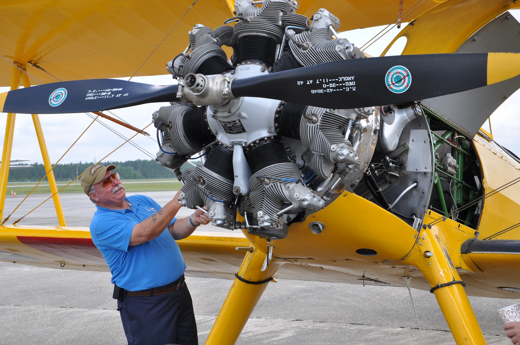 Jay Botsay from Diamondhead, Miss., tends to the engine of his Boeing Stearman Navy N2S4 aircraft shortly after flying in for Joint Safety Day May 18, 2013 at Stennis International Airport in Kiln, Miss. A product of the Mid-Air Collision Avoidance program, the event was open to all area pilots to increase dialogue between the military and civilian aviation communities. (U.S. Air Force photo by Airman 1st Class Stephan Coleman)