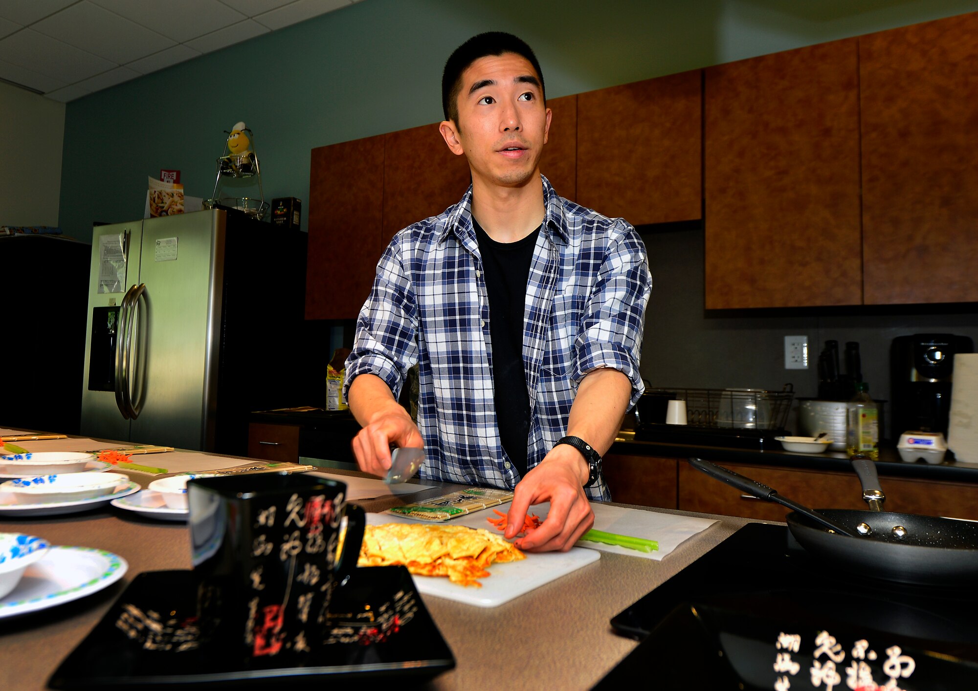 Robert Otsubo, 736th Aircraft Maintenance Squadron hydraulics systems apprentice, teaches an Asian cooking class May 17, 2013, at the Health and Wellness Center on Dover Air Force Base, Del. Otsubo taught the students how to prepare futomaki, a traditional Japanese sushi, tori katsu, a Japanese style breaded chicken and assorted mochi, which is Japanese confections. (U.S. Air Force photo/David Tucker)
