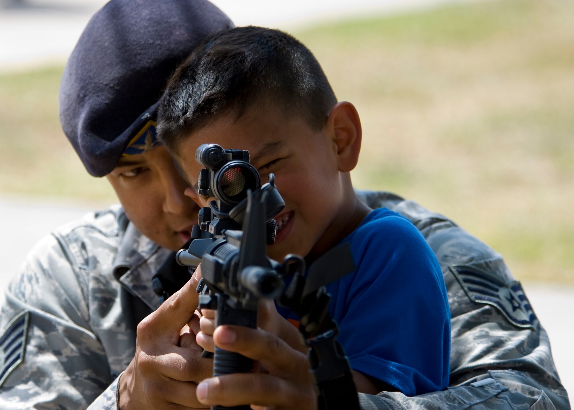 U.S. Air Force Staff Sgt. Timothy Castillo, 7th Security Forces Squadron (SFS), shows his son, Jayce Castillo, how to properly aim down the sights of an M-4 Carbine May 14, 2013, during National Police Week at Dyess Air Force Base, Texas. In 1962, President John F. Kennedy proclaimed May 15 as National Peace Officers Memorial Day and the calendar week in which May 15 falls, as National Police Week. The week pays special recognition to those law enforcement officers who have lost their lives in the line of duty for the safety and protection of others. The 7th SFS held a jail-and-bail fundraiser, vehicle display, weapons display and bike rodeo throughout the week. They also held a retreat ceremony to honor and remember security forces members that have made the ultimate sacrifice.  (U.S. Air Force photo by Airman 1st Class Damon Kasberg/ Released)