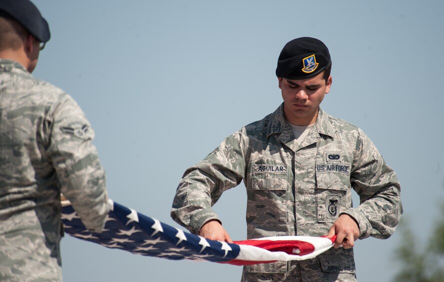 U.S. Air Force Airman 1st Class Dalton Aguilar, 7th Security Forces Squadron, folds an American flag during a Police Week retreat ceremony May 16, 2013, at Dyess Air Force Base, Texas. In 1962, President John F. Kennedy proclaimed May 15 as National Peace Officers Memorial Day and the calendar week in which May 15 falls, as National Police Week. During Police Week, communities across the nation pay tribute to fallen law enforcement heroes for the sacrifices they made to protect others. (U.S. Air Force photo by Senior Airman Jonathan Stefanko/Released)