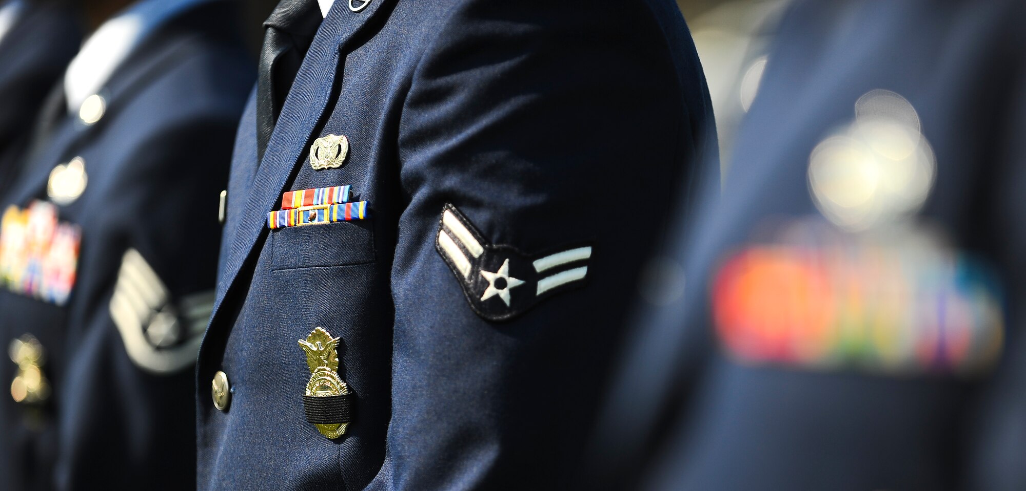 Airmen from the 6th Security Forces Squadron commemorate fallen defenders by placing a symbolic black stripe over their occupational badges May 17, 2013, MacDill Air Force Base, Fla. Each year, during the week of May 15, Airmen Air Force-wide celebrate National Police Officers Week through time honored traditions such as competitions, ceremonies and public displays. (U.S. Air Force photo by Staff Sgt. Angela Ruiz/released)