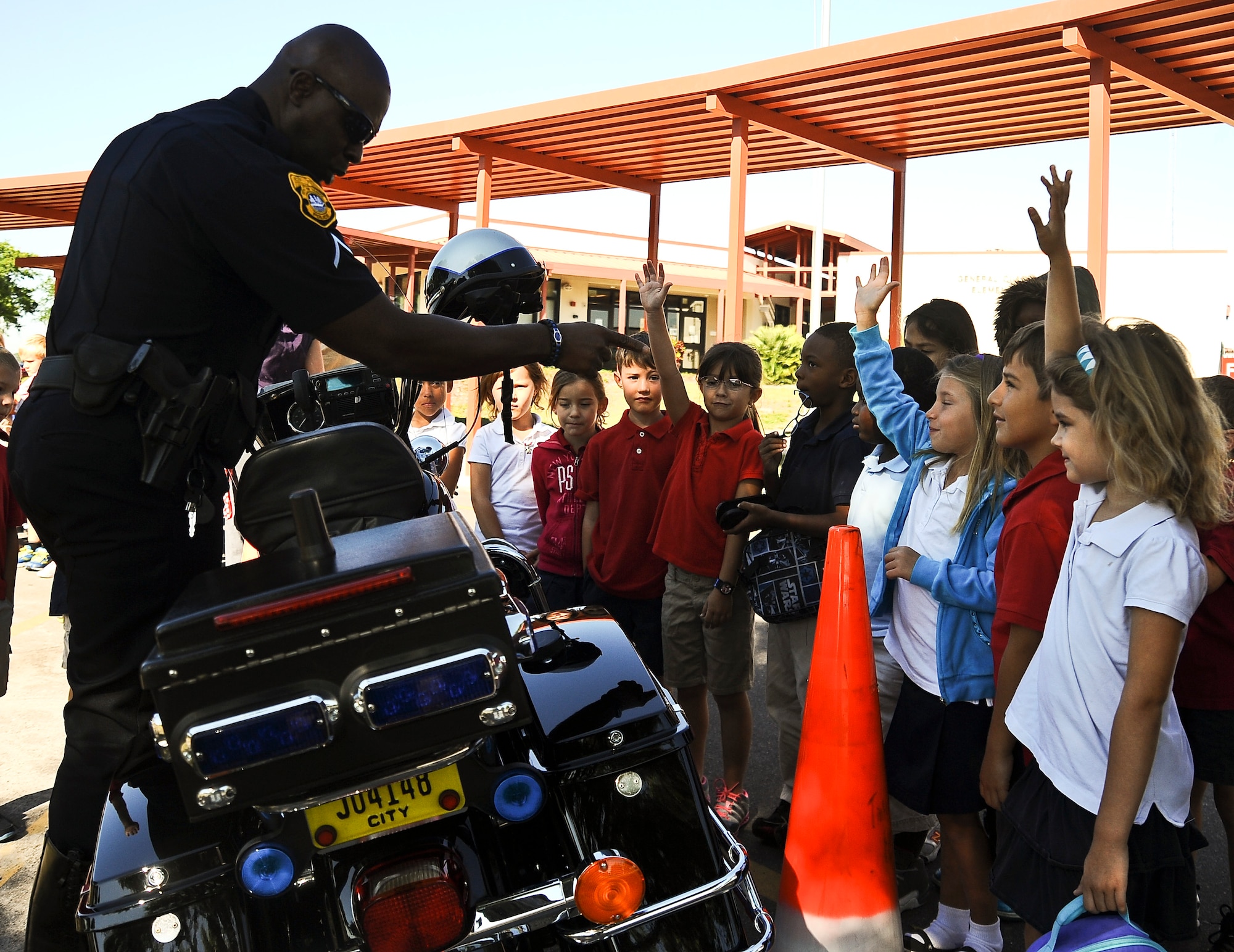 Mike Anderson, master patrolman from the Tampa Police Department, mentors children from Tinker Elementary School on traffic safety on 15 May, 2013 at MacDill Air Force Base, Fla.  Each year, as part of National Police Officer Week, members from the 6th Security Forces Squadron and local police Departments put on a show-and-tell depicting the different aspects involved in public safety. (U.S. Air Force photo by Staff Sgt. Brandon Shapiro/ Released)