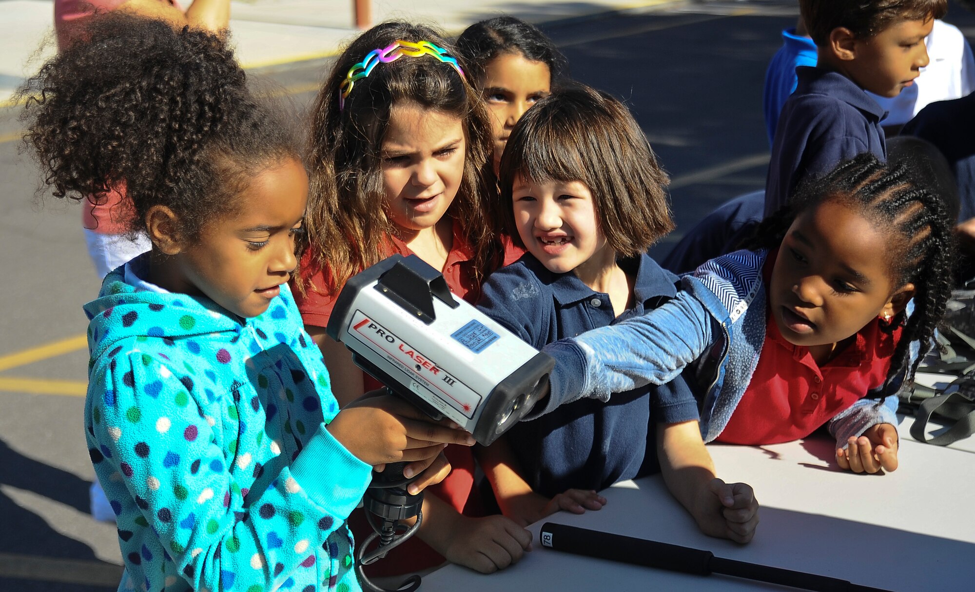 Children from Tinker Elementary School at MacDill Air Force Base, Fla take turns looking at an infrared light detection and ranging gun used to enforce traffic laws May 15, 2013. The 6th Security Forces Squadron set up an equipment demonstration to highlight National Police Officer Week and public safety. (U.S. Air Force photo by Staff Sgt. Brandon Shapiro/released)