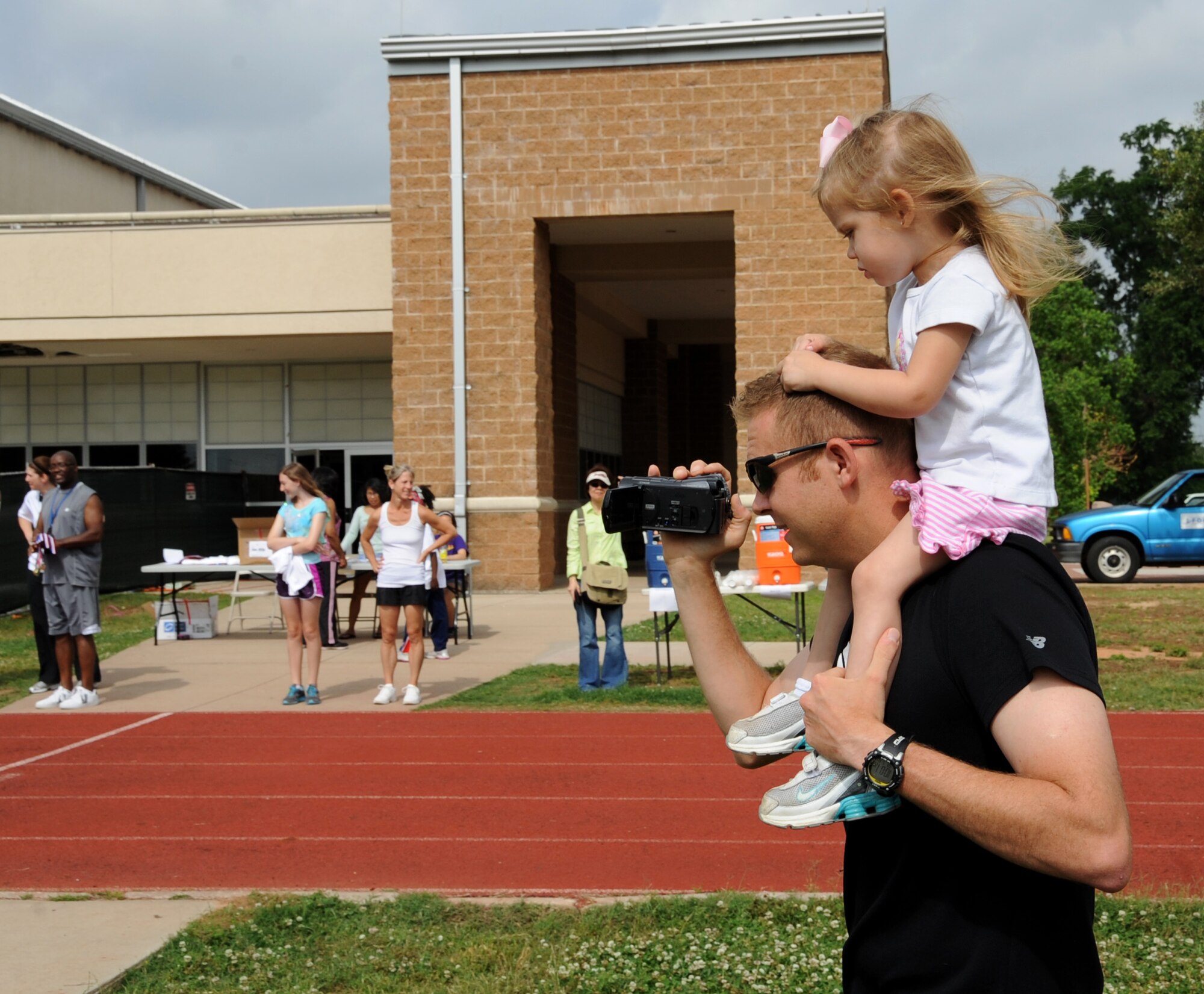 Maj. Christopher Occhiuzzo, Air Force Global Strike Command, records the Kids Run on Barksdale Air Force Base, La., May 18, 2013. The Kids Run was held in conjunction with Armed Forces Day, which celebrates the unification of all military organizations under the Department of Defense. (U.S. Air Force photo/Airman 1st Class Benjamin Gonsier)