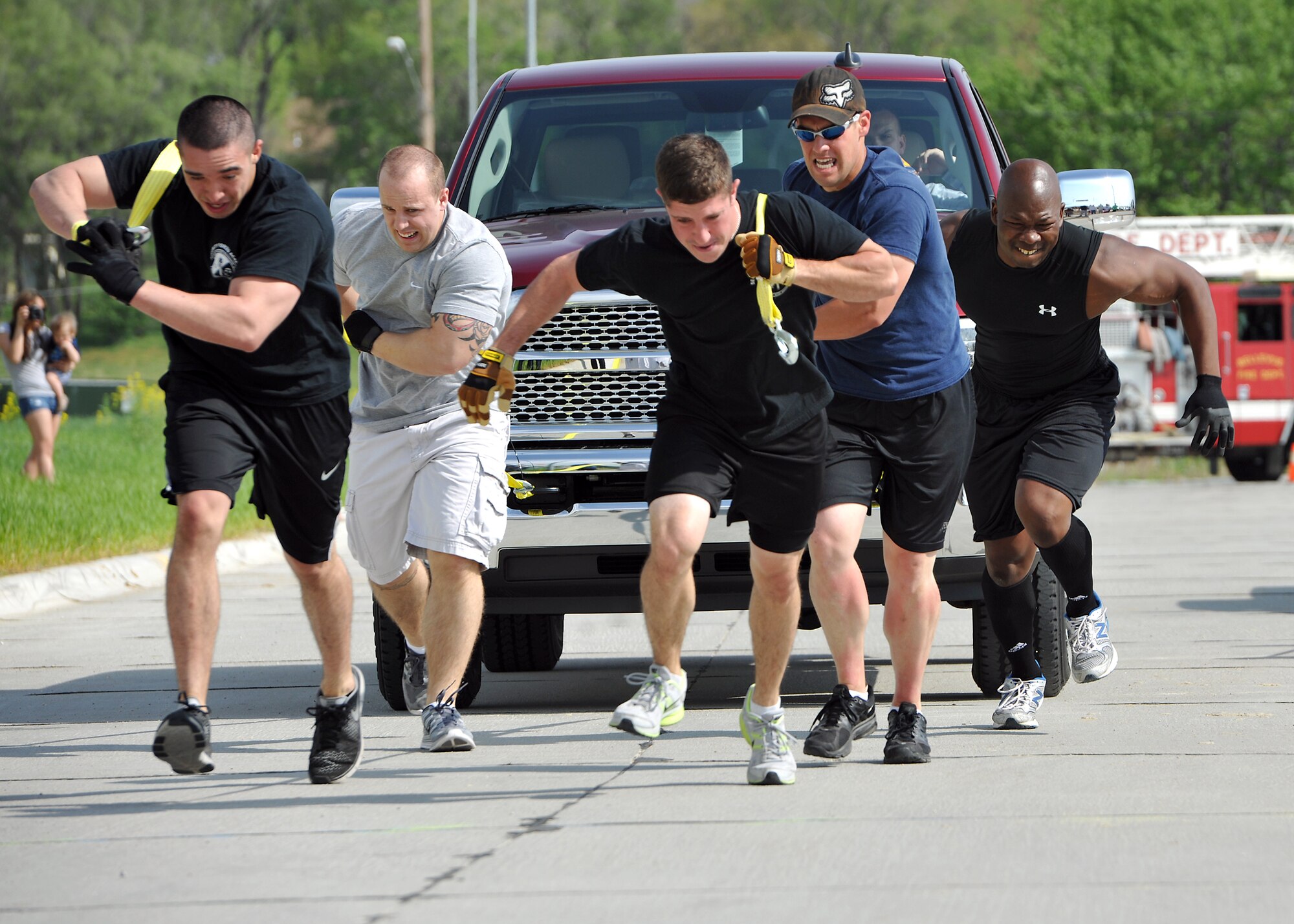 BELLEVUE, Neb. -- (From left to right), U.S. Air Force Senior Airman Nathaniel Urias, Senior Airman Brian Trudeau, Senior Airman Kenneth Jenkins, U.S. Navy Petty Officer 3rd Class Brice Bolchoz and U.S. Air Force Staff Sgt. Marcus Stokes, all members of the 55th Security Forces Squadron, pull a 4-ton pick-up truck as part of the Performance Chrysler Jeep Dodge Ram of Bellevue Truck Pull Competition May 18, 2013.  The team placed second earning their squadron $1,000. (U.S. Air Force photo by Tech. Sgt. Markus M. Maier/Released)