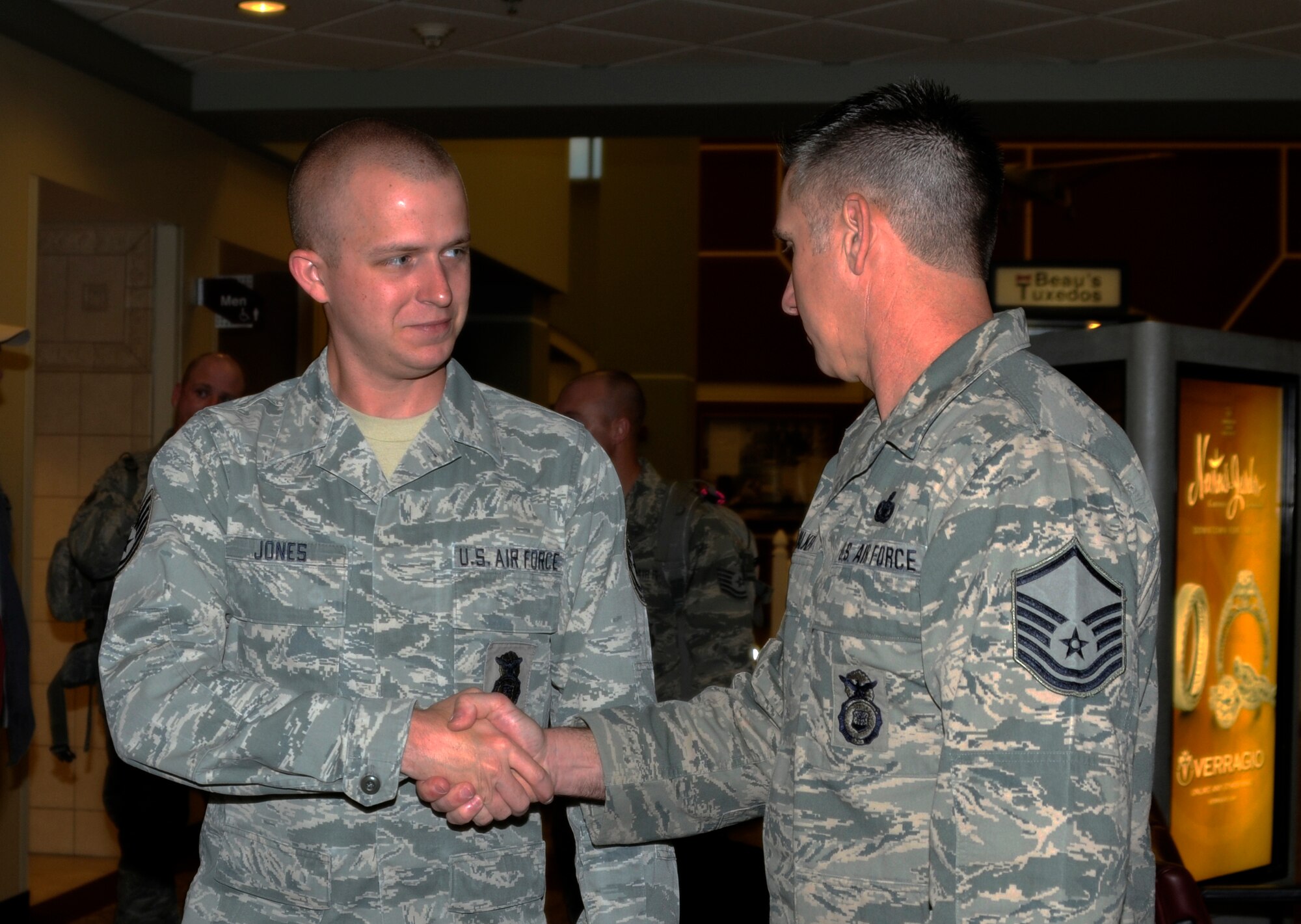 Technical Sgt. Kevin Jones, a force protection specialist with the 188th Fighter Wing’s Security Forces Squadron, shakes Master Sgt. Mike Walker's hand before he boards his flight. Jones departed Fort Smith on a six-month deployment to Southwest Asia in support of Operation Enduring Freedom, May 12, 2013. While there, the 188th SFS will provide installation support and security for assigned aircraft. (U.S. Air National Guard photo by Senior Airman Hannah Landeros/188th Fighter Wing Public Affairs)