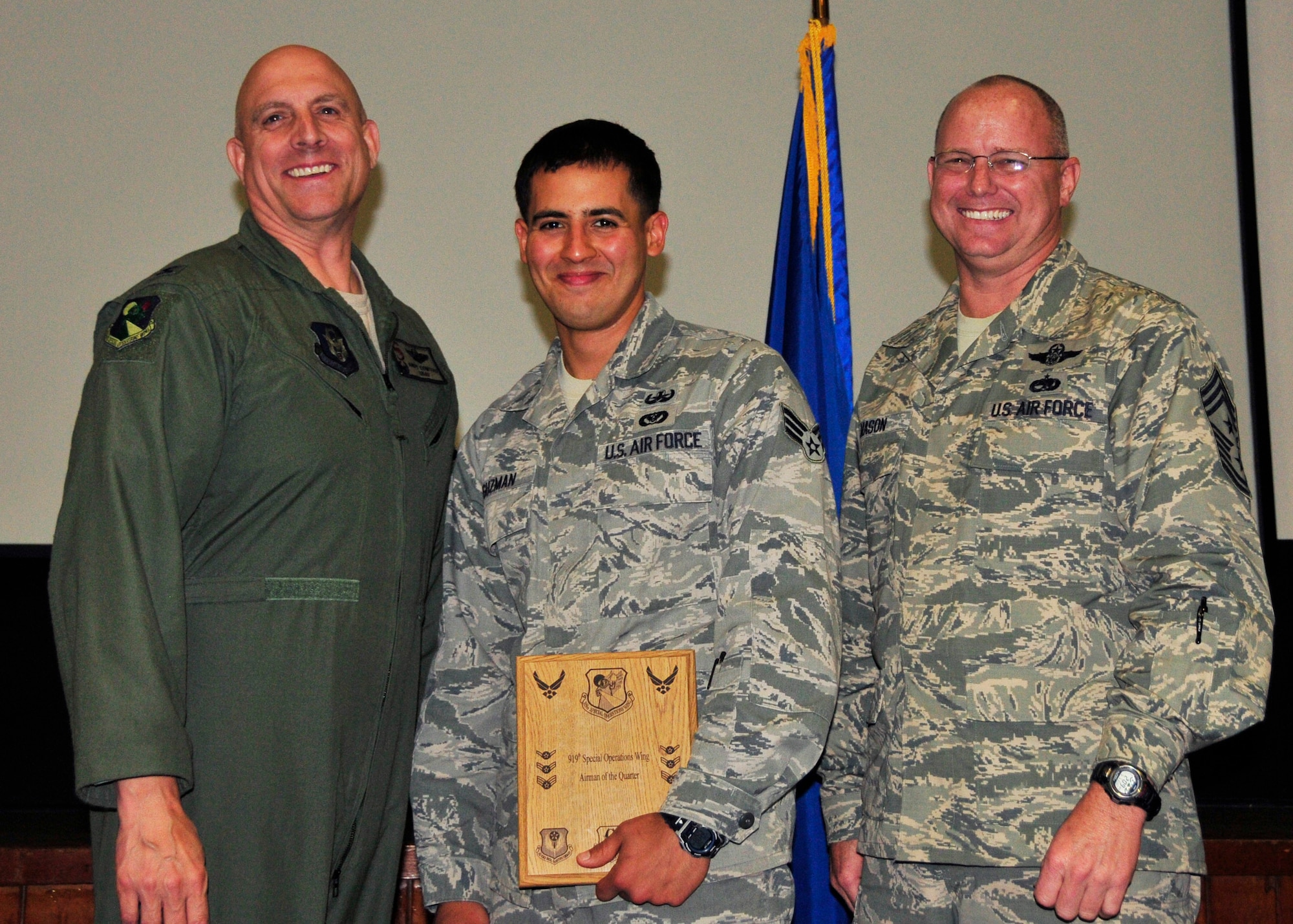 Senior Airman Jeremy Guzman from the 919th Civil Engineer Squadron displays the award he received as the 919th Special Operations Wing Airman of the Quarter May 5, 2013 at Duke Field, Fla. Shown with him from left are Col. Andy Comtois, the 919th SOW commander, and Chief Master Sgt. Tom Mason, the wing’s command chief.  (U.S. Air Force photo/Tech. Sgt Jasmin Taylor)