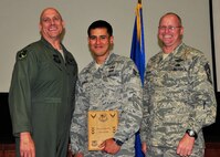 Senior Airman Jeremy Guzman from the 919th Civil Engineer Squadron displays the award he received as the 919th Special Operations Wing Airman of the Quarter May 5, 2013 at Duke Field, Fla. Shown with him from left are Col. Andy Comtois, the 919th SOW commander, and Chief Master Sgt. Tom Mason, the wing’s command chief.  (U.S. Air Force photo/Tech. Sgt Jasmin Taylor)