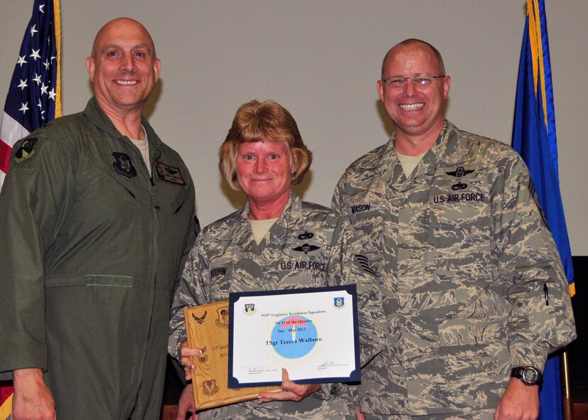Tech. Sgt. Teresa Walborn from the 919th Logistics Readiness Squadron displays the award she received as the 919th Special Operations Wing NCO of the Quarter May 5, 2013 at Duke Field, Fla. Shown with her from left are Col. Andy Comtois, the 919th SOW commander, and Chief Master Sgt. Tom Mason, the wing’s command chief.  (U.S. Air Force photo/Tech. Sgt Jasmin Taylor)

