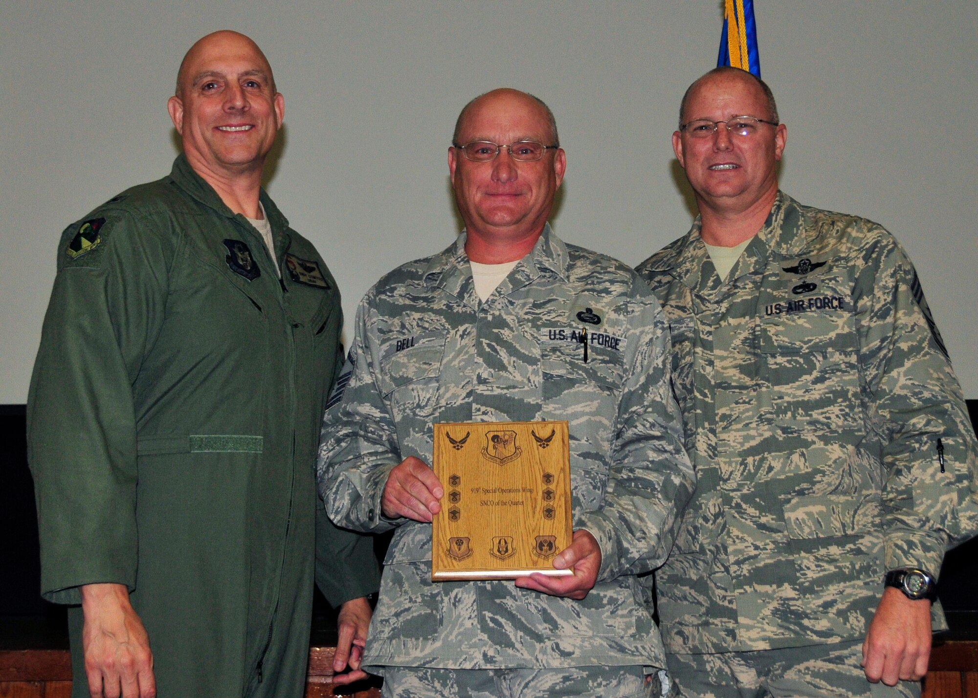 Master Sgt. Randall Bell from the 919th Maintenance Operations Flight displays the award he received as the 919th Special Operations Wing Senior NCO of the Quarter May 5,2013 at Duke Field, Fla.   Shown with him from left are Col. Andy Comtois, the 919th SOW commander, and Chief Master Sgt. Tom Mason, the wing’s command chief.  (U.S. Air Force photo/Tech. Sgt Jasmin Taylor)