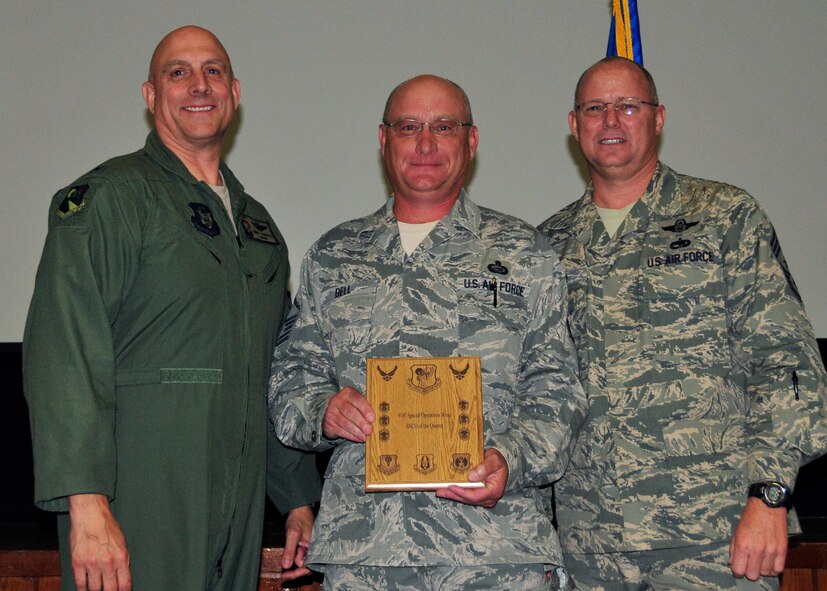 Master Sgt. Randall Bell from the 919th Maintenance Operations Flight displays the award he received as the 919th Special Operations Wing Senior NCO of the Quarter May 5,2013 at Duke Field, Fla.   Shown with him from left are Col. Andy Comtois, the 919th SOW commander, and Chief Master Sgt. Tom Mason, the wing’s command chief.  (U.S. Air Force photo/Tech. Sgt Jasmin Taylor)