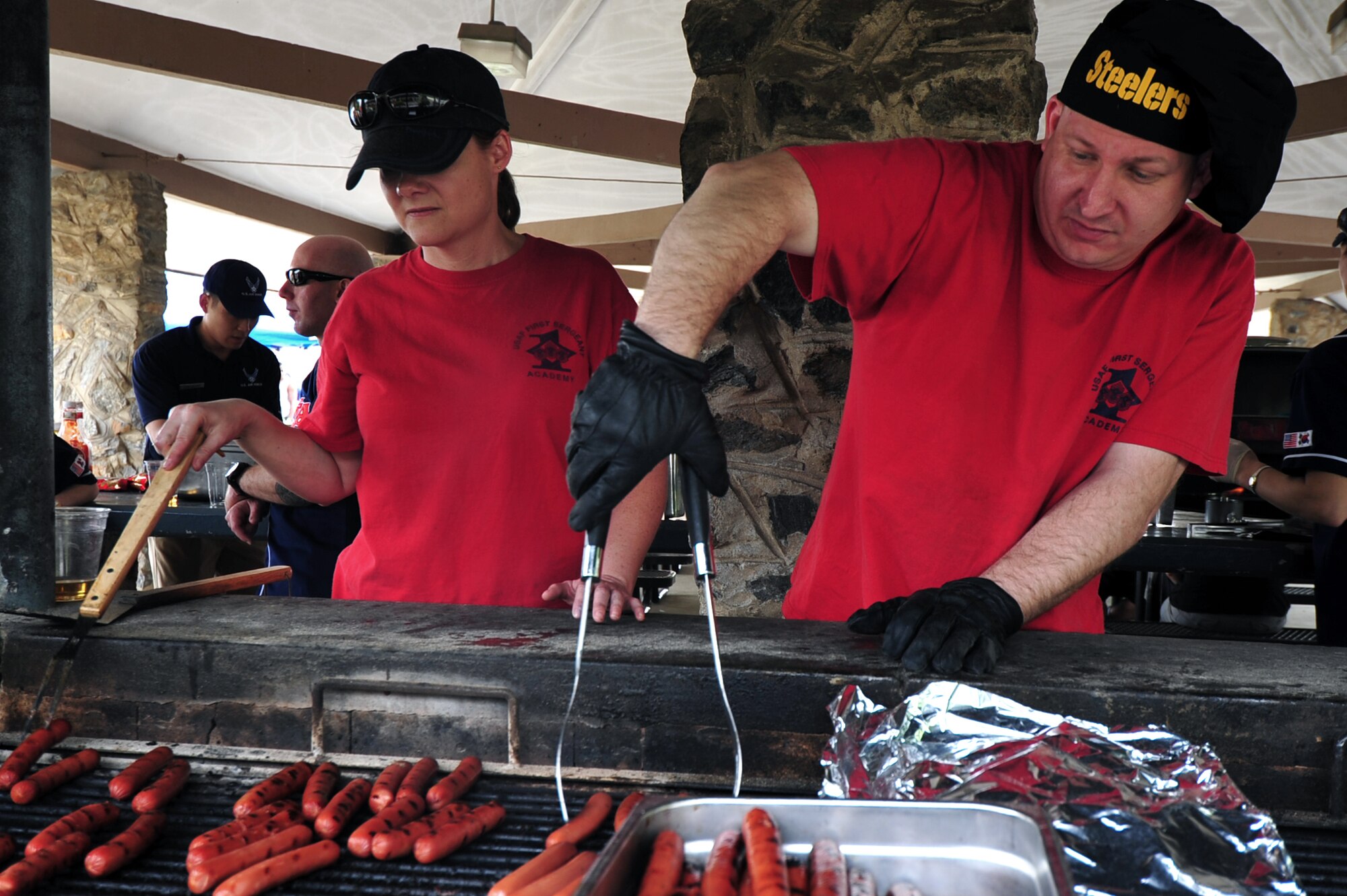 First sergeants grill up hot dogs, hamburgers and a full pig during a free pig roast hosted by the Osan First Sergeants Council at Osan Air Base, Republic of Korea, May 18, 2013. The cookout was hosted to show the Airmen the shirts’ appreciation of what they do every day. (U.S. Air Force photo/Senior Airman Alexis Siekert)