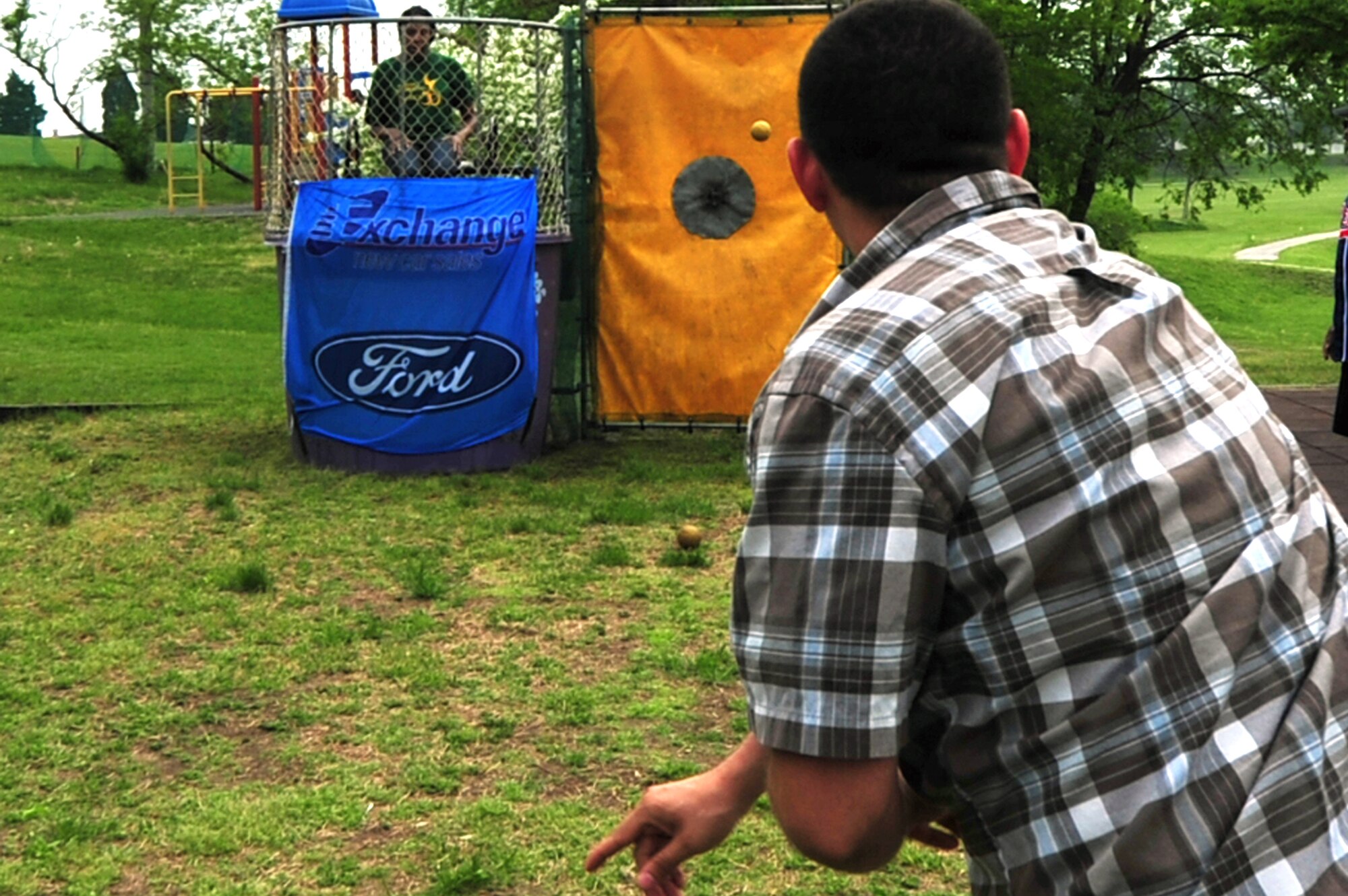 Staff Sgt. Charles Manbeck, 51st Maintenance Squadron avionics technician, throws a ball to dunk Master Sgt. Carol Dorman Gore, 7th Air Force first sergeant, during a free pig roast hosted by the Osan First Sergeants Council at Osan Air Base, Republic of Korea, May 18, 2013. Attendees at the event were treated to free food, games, music and entry into a raffle. (U.S. Air Force photo/Senior Airman Alexis Siekert)