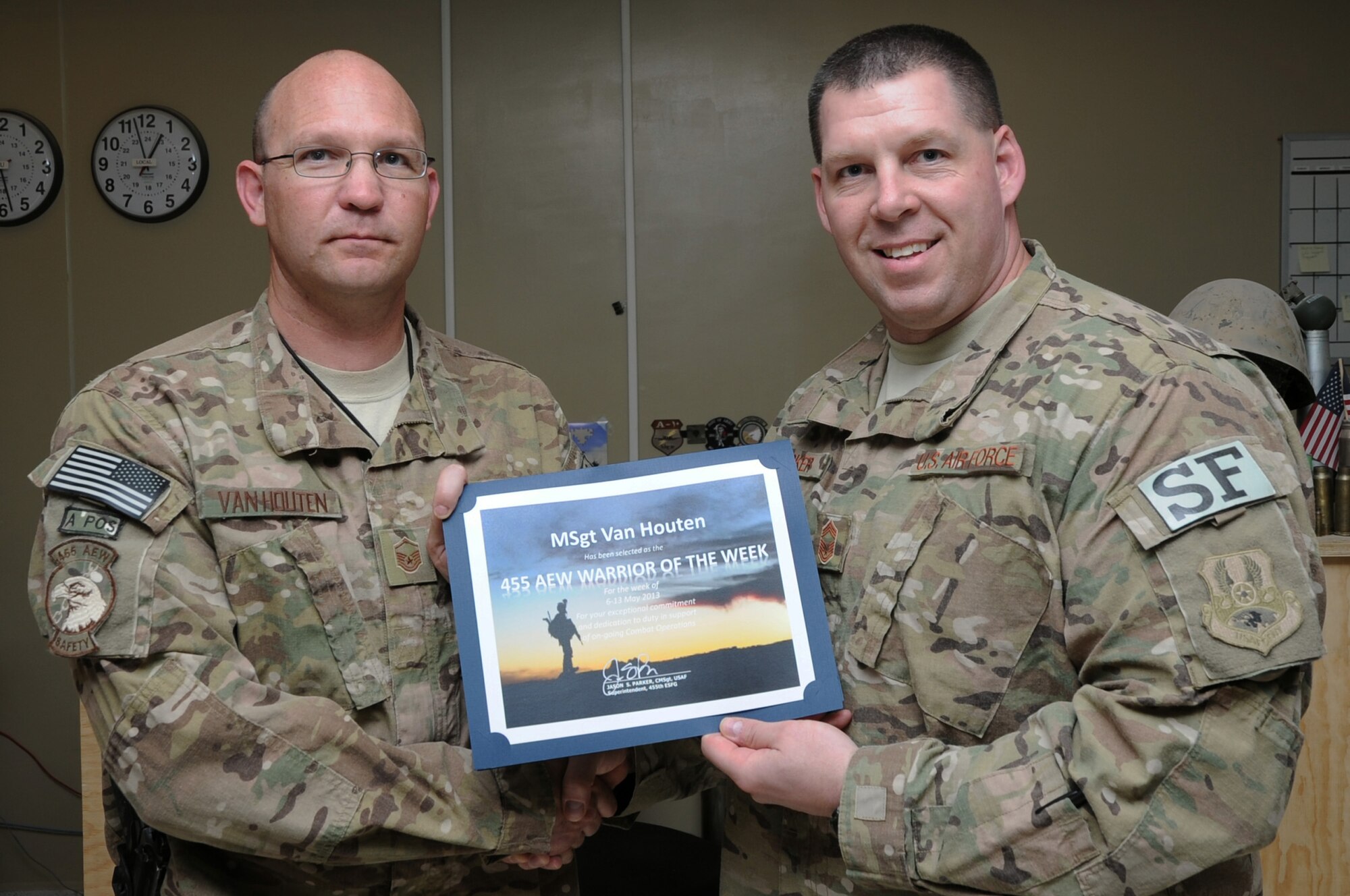 Chief Master Sgt. Jason Parker, 455th Expeditionary Security Forces Group superintendent, presents the "Warrior of the Week" award to Master Sgt. Andrew Van Houten, 455th Air Expeditionary Wing Flight Safety NCO in charge, on Bagram Airfield, Afghanistan, May 17, 2013. Van Houten?s efforts with the Bird Aircraft Strike Hazard team have reduced birdstrikes here by 50 percent. (U.S. Air Force photo/Staff Sgt. David Dobrydney)