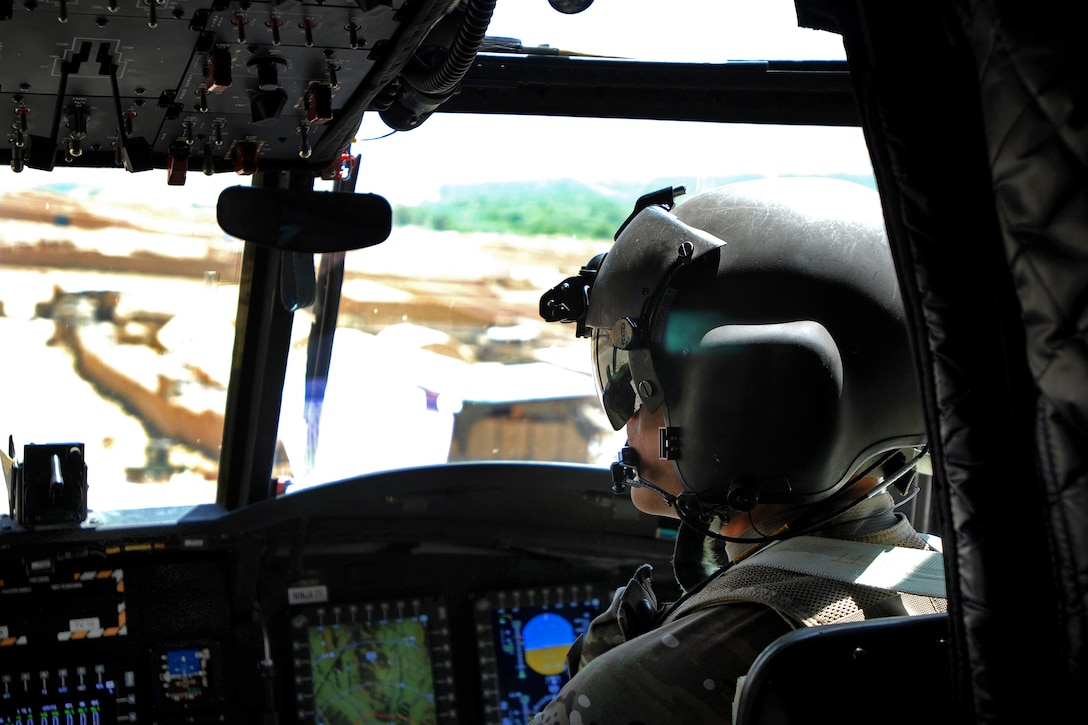 U.S. Army Chief Warrant Officer 2 Matthew Bergquist flies a CH-47 Chinook helicopter over a city in the Chorah district of Uruzgan province, Afghanistan, May 12, 2013. Bergquist, a pilot, is assigned to Company B, 2nd Battalion, 104th Aviation Regiment, Connecticut and Pennsylvania Army National Guard.