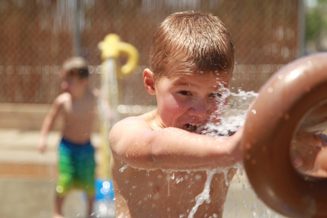 Caleb Barnhurst, 5, stepson of Petty Officer 1st Class Ray Wahl, psychiatrist technician, 7th Marine Regiment, plays with a watergun at the Combat Center’s Splash Park May 8, 2013.