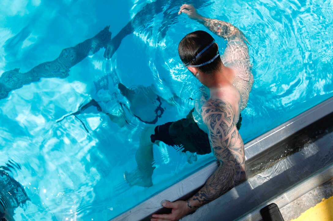 Sgt. Alexander Hale watches as teammate, Sgt. Johnathan Bumpus, assembles an M2-40G machinegun under 15-feet of water at the bottom of the 53-Area pool during the 5th Annual Recon Challenge here May 17. The challenge consisted of a 2,000-meter swim, calisthenics tests and other skill based events.
