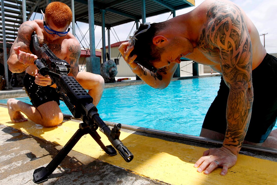 Sgt. Johnathan Bumpus performs a functions check on an M2-40G machinegun that he and his teammate, Sgt. Alexander Hale, assembled under 15-feet of water during the 5th Annual Recon Challenge here May 17. The challenge consisted of a 2,000-meter swim, calisthenics tests and other skill based events.