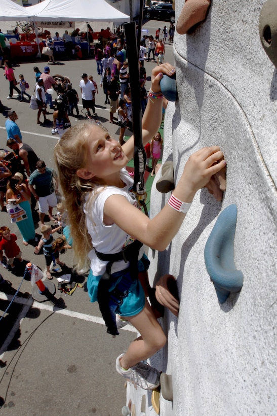Jadyn, 8, climbs a rock-wall at the 12th annual Operation Appreciation at the Oceanside amphitheater May 18.  The Oceanside Chamber of Commerce provided free for, carnival rides and entertainment to all active-duty military and their families. 
