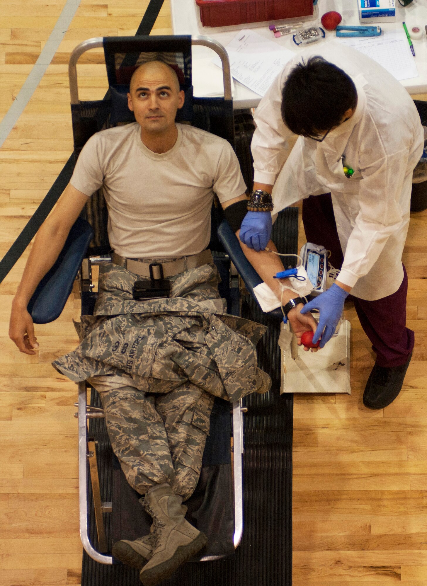 Staff Sgt. Jacob Henry, 422nd Test and Evaluation Squadron weapons director, looks away as Zachariah Schierholz, United Blood Services phlebotomist, tapes a needle in place during a blood drive at the Warrior Fitness Center May 17 at Nellis Air Force Base, Nev. Local hospitals are always in need of new donors due to blood having a shelf life of just 42 days. (U.S. Air Force photo by Airman 1st Class Joshua Kleinholz)