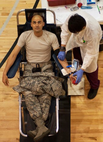 Staff Sgt. Jacob Henry, 422nd Test and Evaluation Squadron weapons director, looks away as Zachariah Schierholz, United Blood Services phlebotomist, tapes a needle in place during a blood drive at the Warrior Fitness Center May 17 at Nellis Air Force Base, Nev. Local hospitals are always in need of new donors due to blood having a shelf life of just 42 days. (U.S. Air Force photo by Airman 1st Class Joshua Kleinholz)