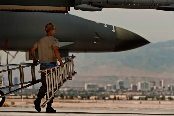 U.S. Air Force Senior Airman Matthew Crow, 7th Aircraft Maintenance Squadron crew chief, carries a ladder to work on a B-1B Lancer before taking part in a Green Flag exercise May 21, 2013, at Nellis Air Force Base, Nev. Aircraft and crews fly from Nellis AFB, Nev., during Green Flag-West exercises in support of ground combat training at Fort Irwin, Calif. (U.S. Air Force photo by Senior Airman Daniel Hughes)