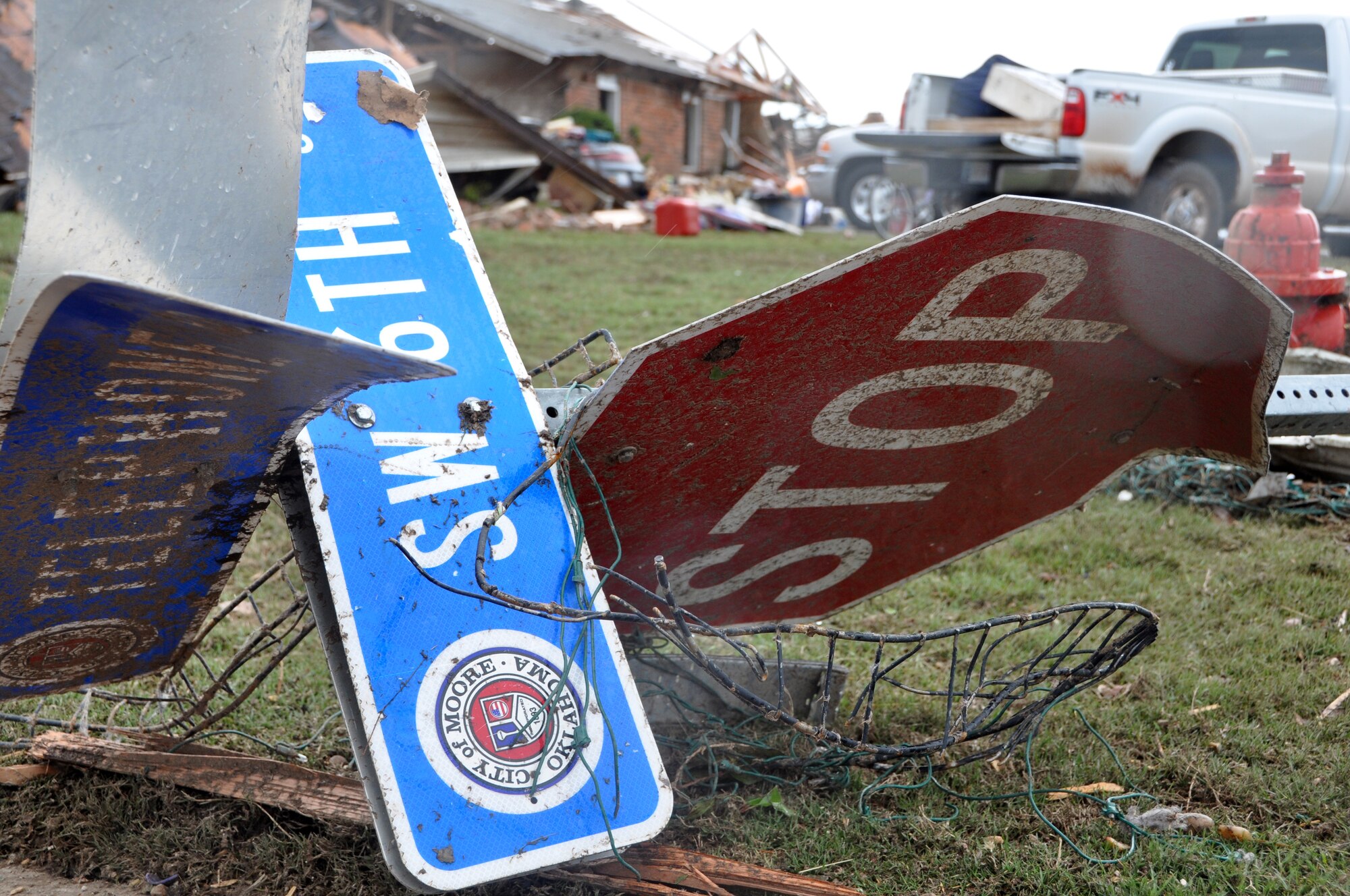 A twisted up sign from SW 6th and Telephone Road landed in the front yard of 137th Air Refueling Wing Oklahoma Air National Guard member, Master Sgt. Cherry Bina.  Bina’s house was destroyed during the massive tornado that ripped through Moore Okla., on May 20, 2013.  (U.S. Air Force photo by Senior Airman Mark Hybers)