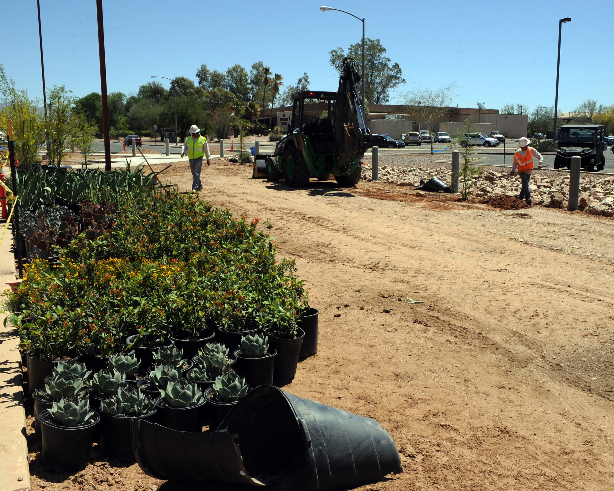 Contractors prepare to place plants in the construction area of the walking plaza to be built at Davis-Monthan Air Force Base, Ariz., April 18, 2013. Though the walking plaza is being built now, it was paid for with money from the Fiscal Year 2012 budget. (U.S. Air Force photo by Senior Airman Timothy Moore/Released)