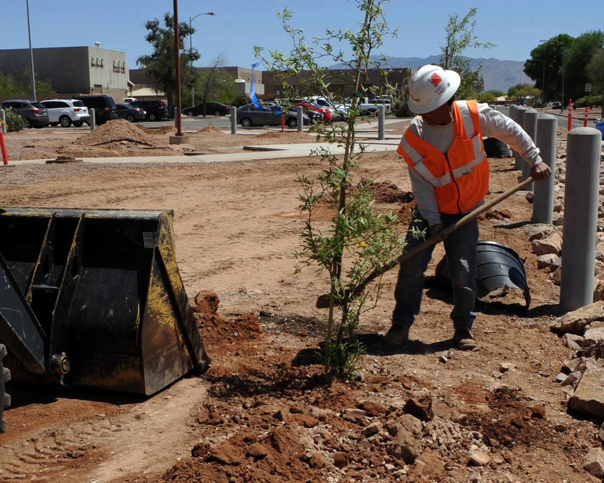 A contractor fills a hole around a plant in the construction area of the walking plaza to be built at Davis-Monthan Air Force Base, Ariz., April 18, 2013. Though the walking plaza is being built now, it was paid for with money from the Fiscal Year 2012 budget. (U.S. Air Force photo by Senior Airman Timothy Moore/Released)