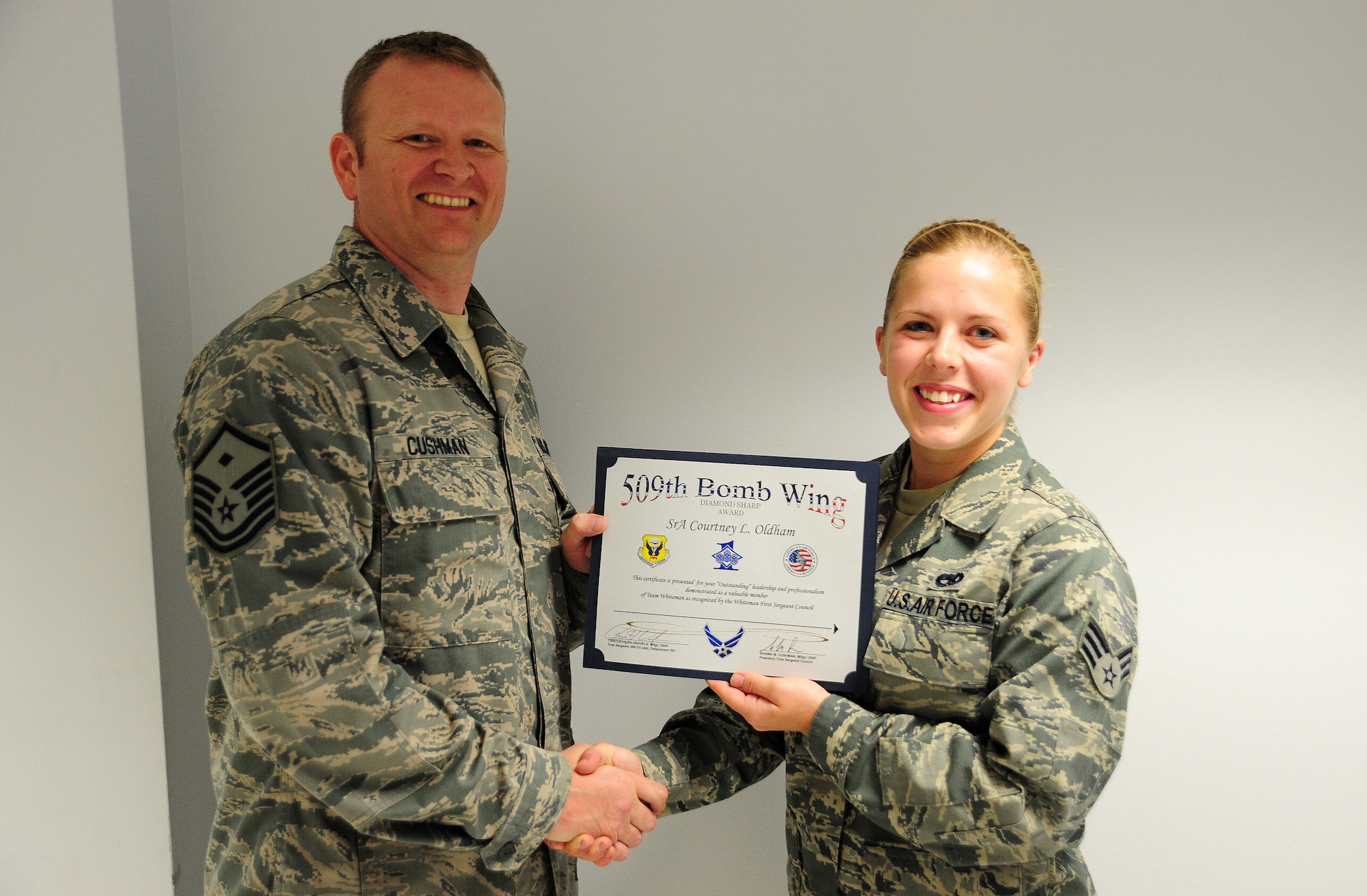 Master Sgt. Shawn Cushman, 509th Civil Engineer Squadron First Sergeant, presents the Diamond Sharp Award to Senior Airman Courtney Oldham, 495th Fighter Group assistant A-10 Thunderbolt dedicated crew chief at Whiteman Air Force Base, May 20, 2013. The Diamond Sharp award is the First Sergeants Council’s recognition for Airmen who have stood out while performing the mission. Accomplishments that contributed to her receiving the award include contributing 96 hours to Airmen Against Drunk Driving and leading two fundraising events to collect $830. She also monitored children for Heart Link which enabled new Air Force spouses to attend orientation. (U.S. Air Force photo by Staff Sgt. Nick Wilson/Released)