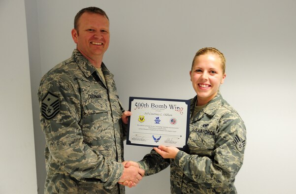 Master Sgt. Shawn Cushman, 509th Civil Engineer Squadron First Sergeant, presents the Diamond Sharp Award to Senior Airman Courtney Oldham, 495th Fighter Group assistant A-10 Thunderbolt dedicated crew chief at Whiteman Air Force Base, May 20, 2013. The Diamond Sharp award is the First Sergeants Council’s recognition for Airmen who have stood out while performing the mission. Accomplishments that contributed to her receiving the award include contributing 96 hours to Airmen Against Drunk Driving and leading two fundraising events to collect $830. She also monitored children for Heart Link which enabled new Air Force spouses to attend orientation. (U.S. Air Force photo by Staff Sgt. Nick Wilson/Released)