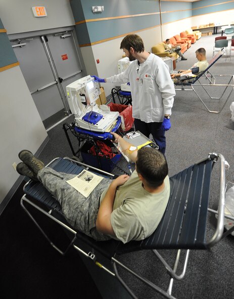 Senior Airman Jeffrey Ferguson, 442nd Maintenance Squadron volunteer blood donor, gives blood as Clark Merle, American Red Cross collection technician, ensures the process runs smoothly during a blood drive at Whiteman Air Force Base, Mo., May 16, 2013. The American Red Cross is the largest provider of blood products in the U.S. and distributes to more than 3,000 transfusion centers and hospitals across the country. (U.S. Air Force photo by Staff Sgt. Nick Wilson/Released)